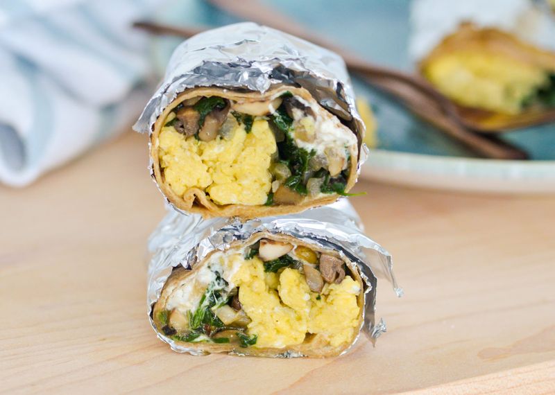 stacked mushroom breakfast burrito with egg wrapped in foil