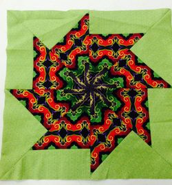 quilt block with light green border, black purple green and red center