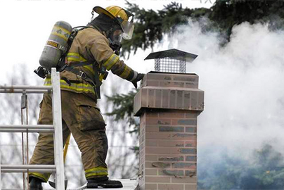firefighter inspecting chimney fire