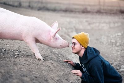 Teen nose to nose with a pig