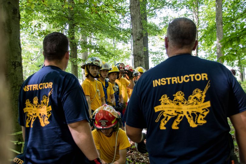 Two instructors teaching several youths during Junior Firefighter Camp.