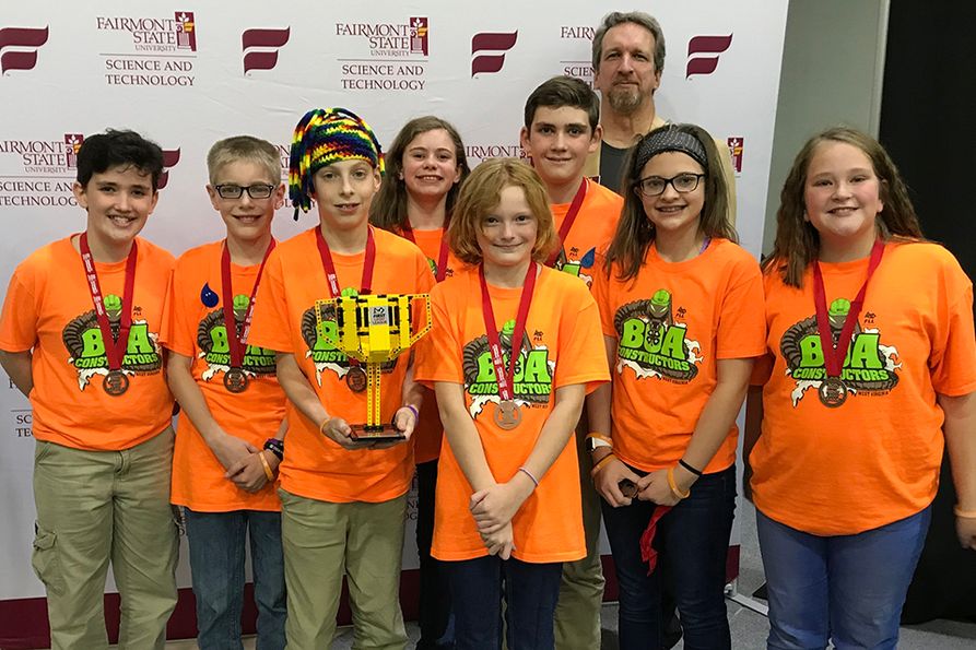 Members of Monroe County 4-H robotics team pose with state championship trophy 