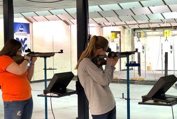 Two teens, holding air rifles aimed at targets participate, in West Virginia's state 4-H Shooting Sports Championships at WVU's mobile rifle range in Morgantown.