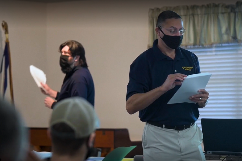 Denis Scott (back left) and Tony Michael (front right) hand out papers at a cultural competency training in Huntington, West Virginia. 