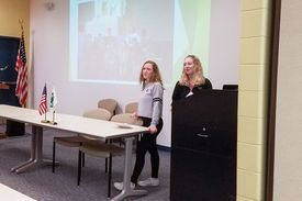 two teenage girls giving 4-H presentation in front of powerpoint screen