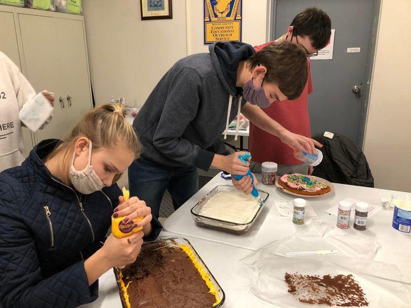 Youth decorating cakes