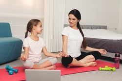 mother and daughter on yoga mat