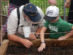 Chuck Talbott shows a youth about square foot gardening.