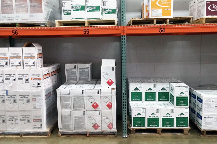 Rows of boxes of pesticides sit on shelves.