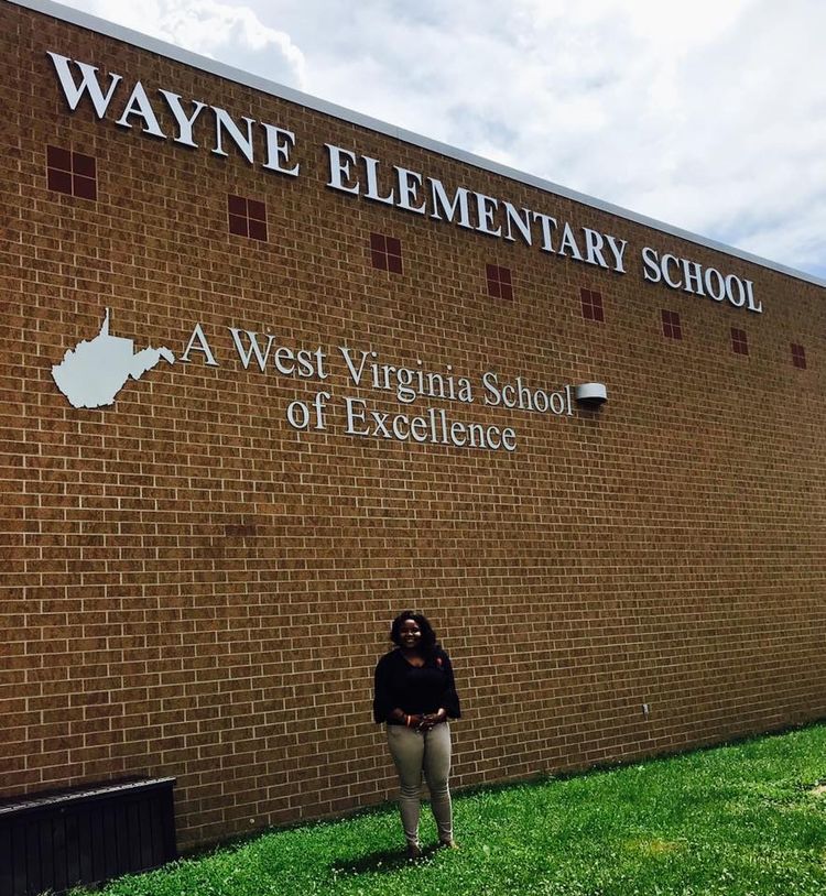 2018 CEOS International Student Line-Audrey stands in front of Wayne Elementary School building