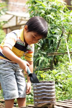Boy Filling Container with Soil