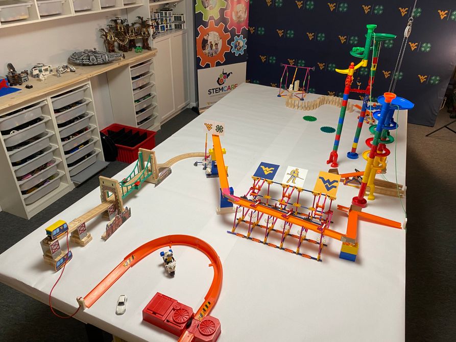 Picture of a Rube Goldberg machine that uses marbles, toys, cars, legos and other items to create a chain reaction of events.