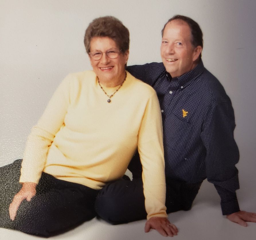 Photo of Sue Jones on the left, seated, and Randall Jones seated on the right - both in WVU gear/colors