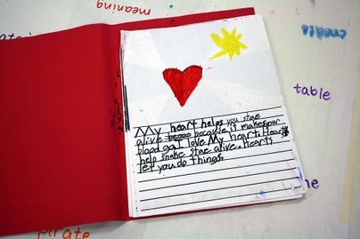 child's journal entry with art of heart and sun above writing