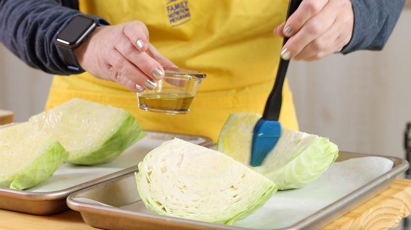 person brushing cabbage wedges with avocado oil