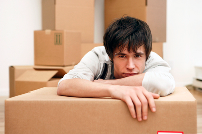 young man leaning on moving boxes