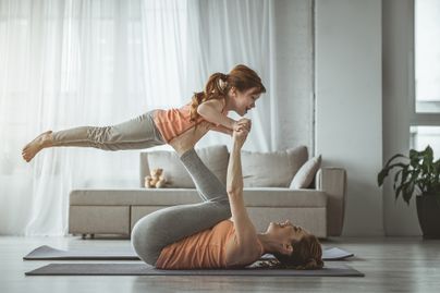mother and daughter exercising on yoga mat.