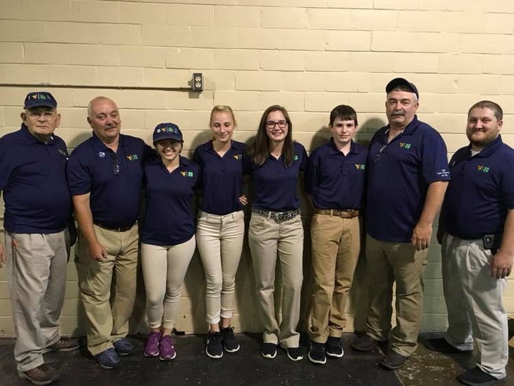 posed shot of air rifle team members standing in front of a wall