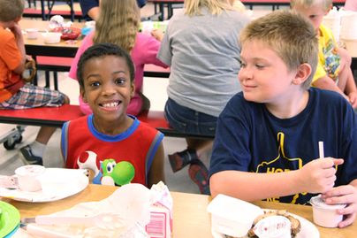 two boys eating lunch in school cafeteria