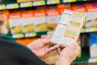woman looking at the food label on back of food box