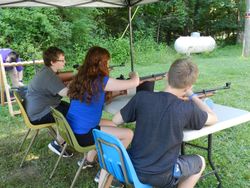 Three youth participating in an Air Rifle class at 4-H Camp