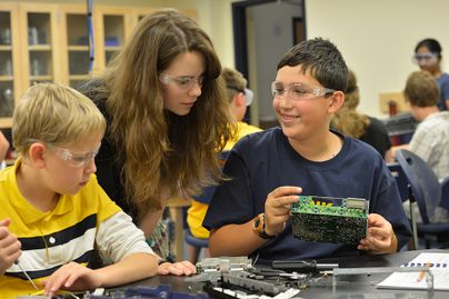 Two youth learn computers with an adult at 4-H code camp