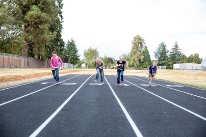 Four kids running on a track
