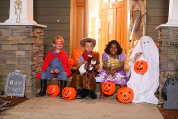 Trick-or-treater's on a porch.
