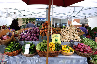 farmers market stand with baskets of vegetables