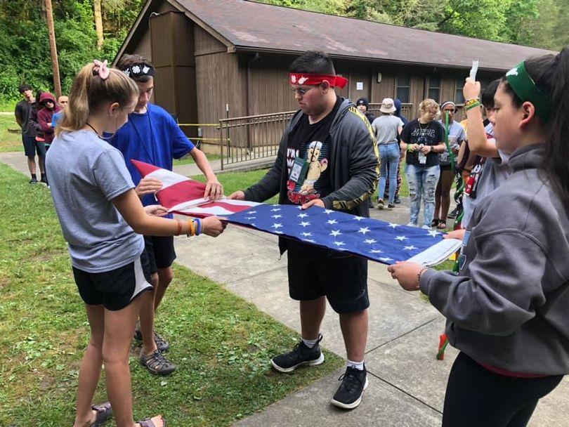 youth folding a US flag