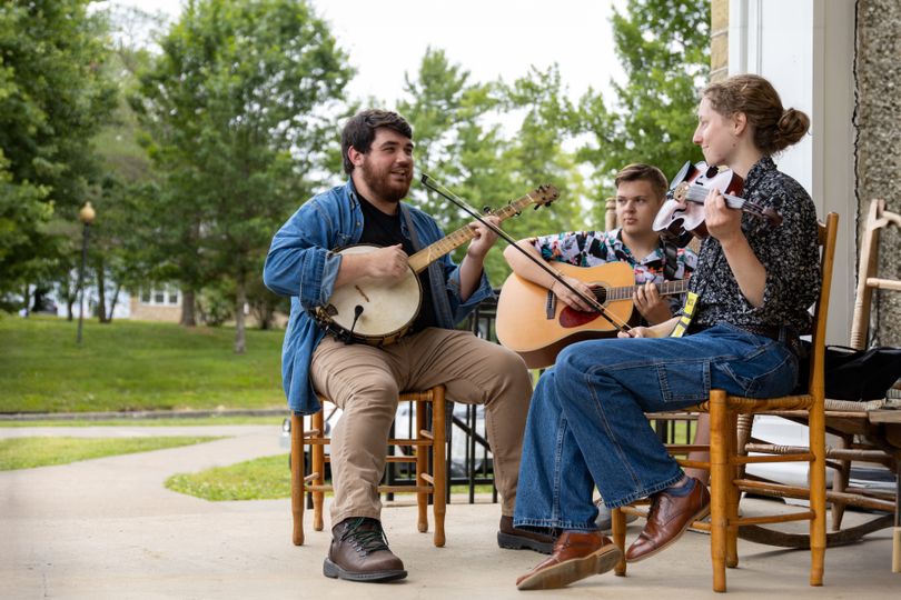 Ryan Brandenburg and two other string band players perform on the porch of the Dining Hall at WVU Jackson's Mill.