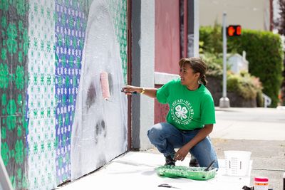 Teenager painting a mural