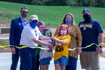 WVU Extension Dean Jorge Atiles stands with a group of Extension supporters as a ceremonial ribbon is cut to open WVU Extension's Shooting Sports facility.