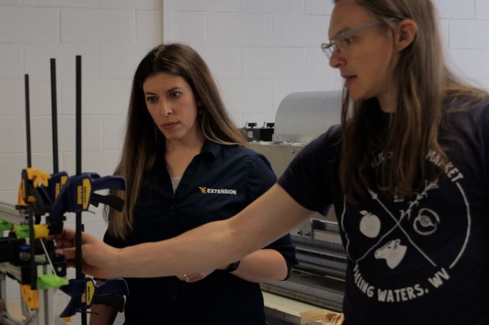 Lisa Jones (left), program coordinator for the WVU Extension Small Farm Center Program, and WVU researcher Jordon Masters examine a spinning machine that could help small producers process wool more effectively.