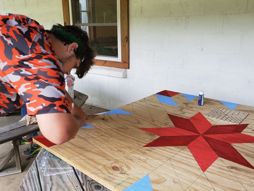 Spirit of Camp, Charles Wells, paints a barn quilt. 