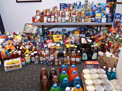 A large pile of food cans, drink jugs, and food boxes