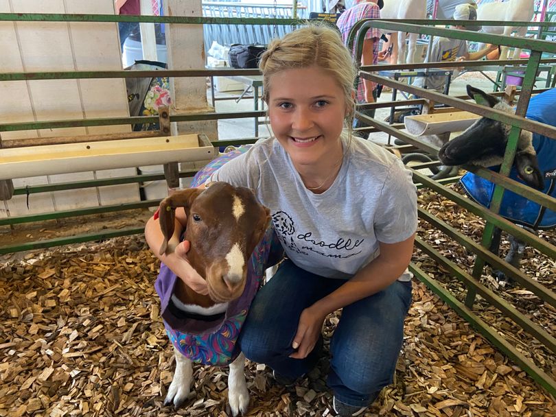 A 4-H'er hugs her show goat during the 2021 State Fair.