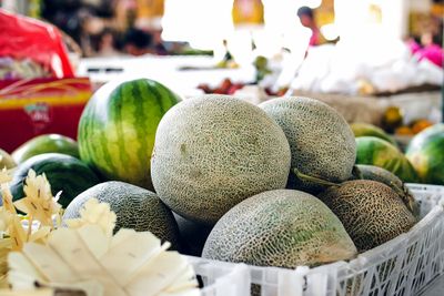 cantaloupes and watermellons stacked at a farmers market
