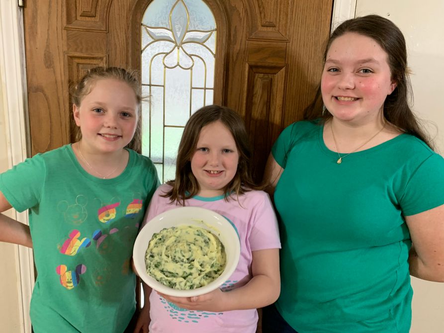 Adkins family holding an Irish dish called Colcannon that they made