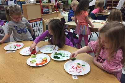 Children participate in a vegetable stamping activity during Show Me Nutrition class.