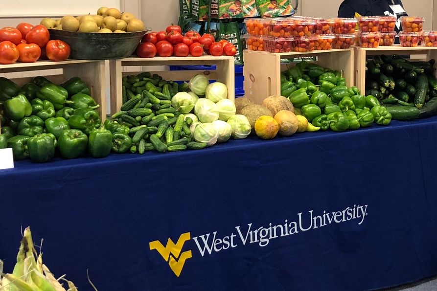 Photos of assorted vegetables on a table with WVU tablecloth