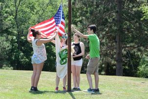 Hancock County 4-H'ers Alaina Norton, Audrey Malcomb, MacKenzie Moore, and Daniel Mayfield lower flag at camp