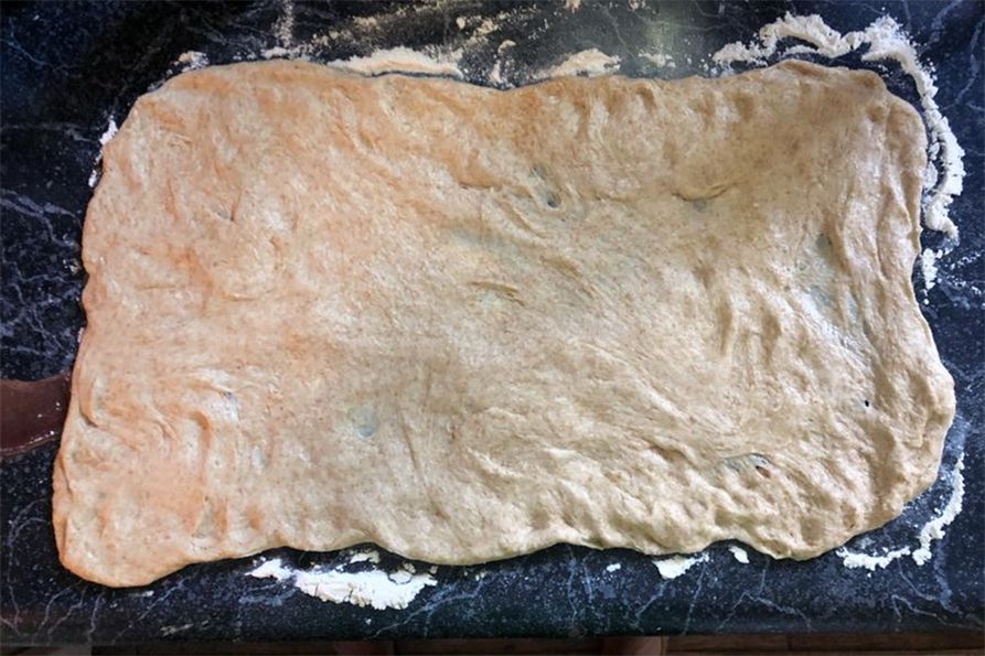 Whole wheat dough for making cinnamon rolls spread out flat.