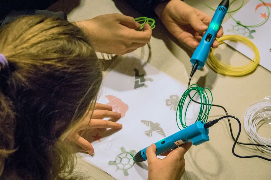 Students use 3-D printing pens to create symbols