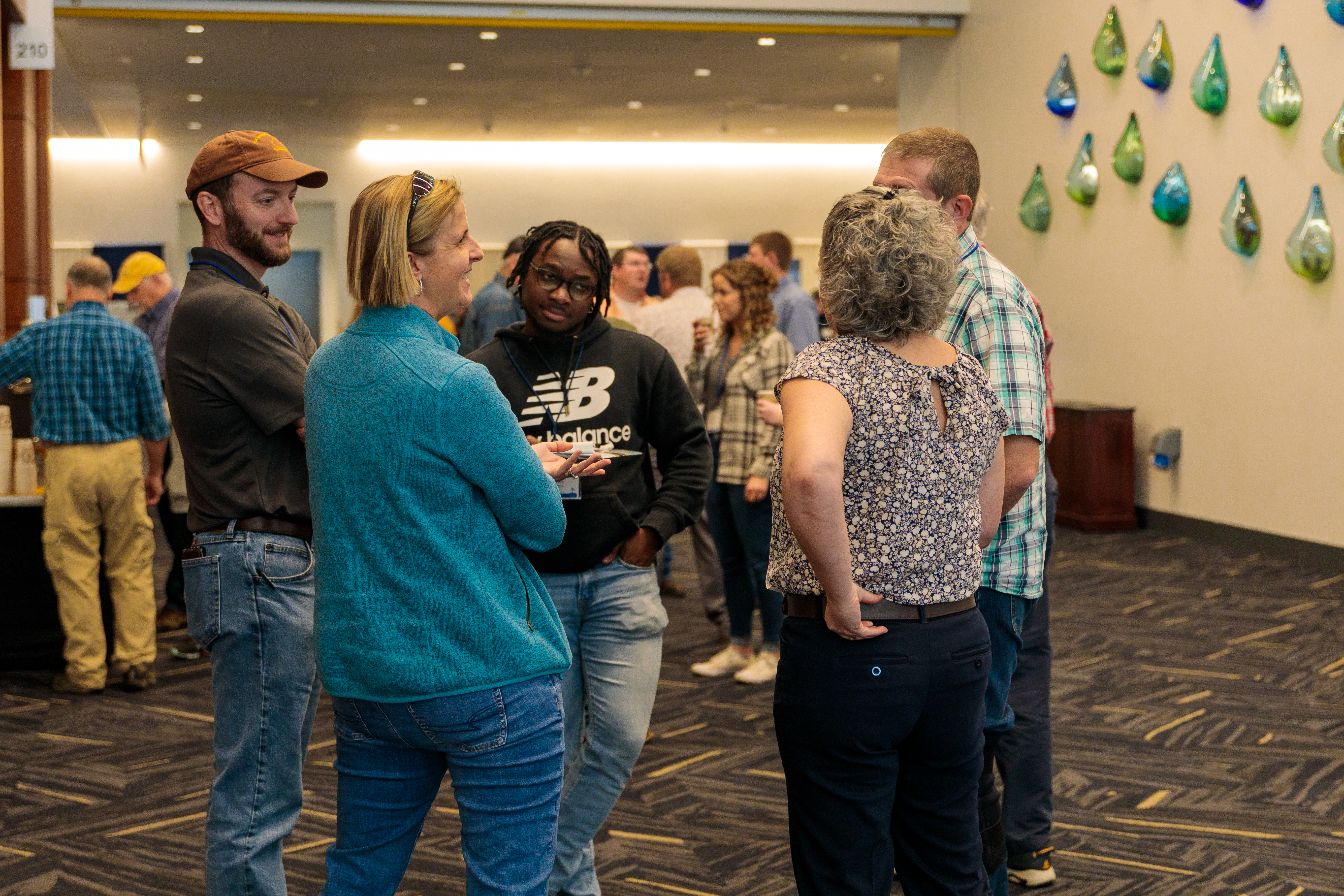 Group of people stand in a circle talking at the Small Farm Conference.