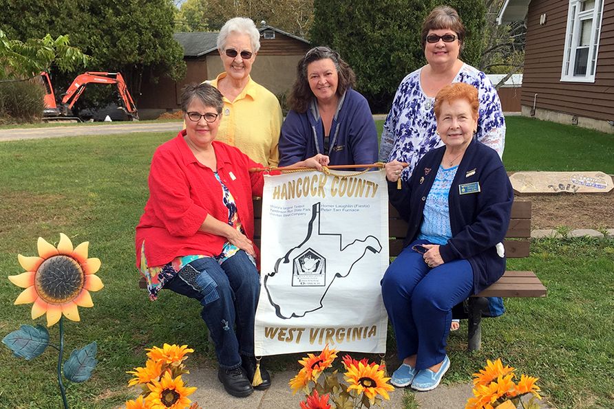 Five Newview members at the WVCEOS Conference at Jackson's Mill pose with a banner reading, "Hancock County CEOS."
