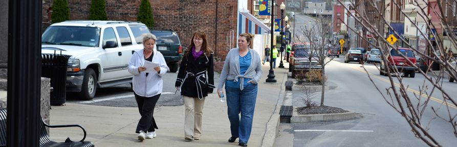 West Virginia University Extension Service Community Development educators walking down a community sidewalk and conducting a walkability study. 