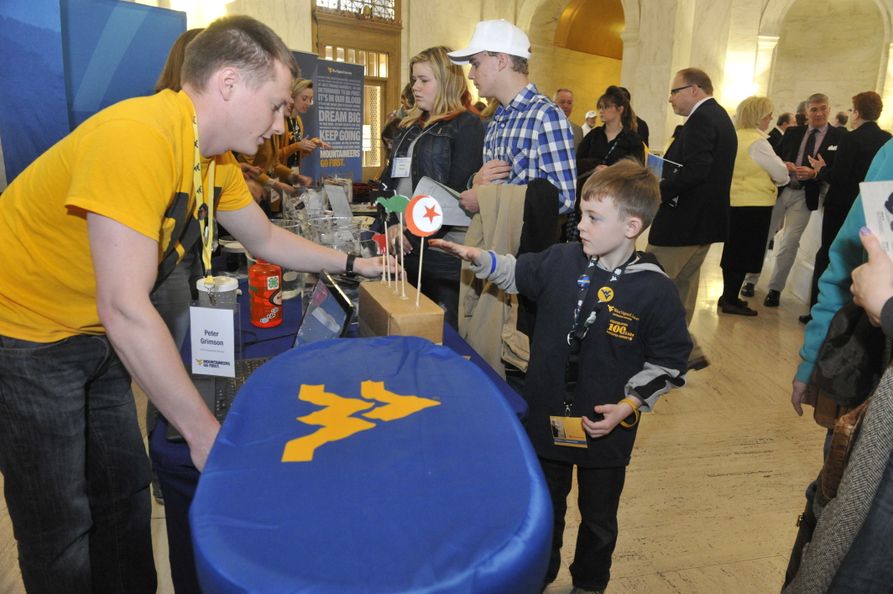 Youths interacting with WVU exhibits at WVU Day at the Legislature at the West Virginia Capitol Building.