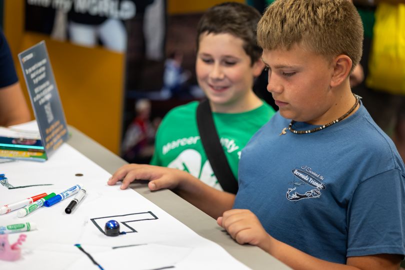 Two 4-H'ers doing Ozobots activity at 4-H Building at State Fair. 