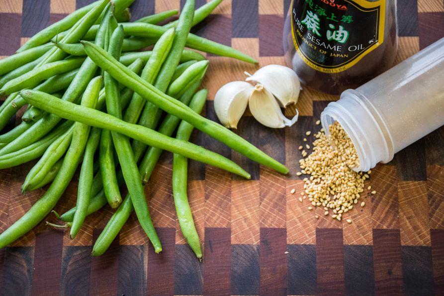 Ingredients for garlic-sesame green beans on cutting board